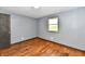 Bedroom featuring hardwood floors, gray walls and a window offering natural light and outdoor views at 11309 N County Road 750 W, Elwood, IN 46036