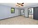 Bedroom with gray walls, carpeted flooring, a ceiling fan, and mirrored closet doors at 11309 N County Road 750 W, Elwood, IN 46036