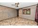 Bedroom featuring a sliding barn door, ceiling fan, wood walls, and tile flooring at 11309 N County Road 750 W, Elwood, IN 46036