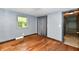 Bedroom featuring hardwood floors, gray walls, a window, and a closet with sliding door at 11309 N County Road 750 W, Elwood, IN 46036