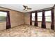 Bedroom with ceiling fan, three windows with dark curtains, and wood-paneled walls at 11309 N County Road 750 W, Elwood, IN 46036