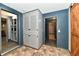 Hallway featuring a built-in cabinet, wood-paneled walls, and tile flooring at 11309 N County Road 750 W, Elwood, IN 46036