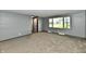 Living room featuring neutral carpet, gray walls and a large window offering natural light and outdoor views at 11309 N County Road 750 W, Elwood, IN 46036
