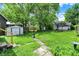 The backyard has a well-maintained lawn, a shed for storage, and a paved pathway at 1138 N Oxford St, Indianapolis, IN 46201