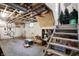 Unfinished basement with exposed ceiling, window, and stairs, ideal for storage or renovation at 1138 N Oxford St, Indianapolis, IN 46201