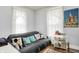 Comfortable bedroom with a patterned sofa, throw pillows, and a decorative world artifact poster at 1138 N Oxford St, Indianapolis, IN 46201