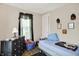 Simple bedroom with a comfortable bed, dark curtains, and personal wall decor at 1138 N Oxford St, Indianapolis, IN 46201