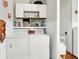 Functional laundry room with washer, dryer, shelving, and a small closet for storage at 1138 N Oxford St, Indianapolis, IN 46201