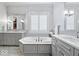 Well-lit bathroom with a soaking tub between two vanities, all in neutral colors at 11404 Hanbury Manor Blvd, Noblesville, IN 46060
