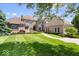 Beautiful front yard featuring lush green grass, manicured landscaping, and a stone and stucco home at 11404 Hanbury Manor Blvd, Noblesville, IN 46060