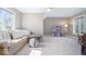 Spacious bonus room features a comfortable couch, windows, and a dollhouse at 11404 Hanbury Manor Blvd, Noblesville, IN 46060