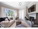 Comfortable living room featuring a fireplace, a large window, and plush furniture at 11404 Hanbury Manor Blvd, Noblesville, IN 46060