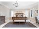 Well-lit main bedroom with a decorative rug, a bench seat, and large windows at 11404 Hanbury Manor Blvd, Noblesville, IN 46060