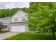 Two-story home with light siding, a two-car garage, manicured lawn, and mature trees at 11919 Gatwick View Dr, Fishers, IN 46037