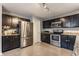 Bright kitchen with stainless steel appliances, dark cabinets, granite countertops and tile floors at 11919 Gatwick View Dr, Fishers, IN 46037