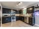 Well-lit kitchen with dark cabinetry, stainless steel appliances, and granite countertops at 11919 Gatwick View Dr, Fishers, IN 46037