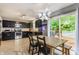Modern kitchen features dark cabinets, stainless steel appliances, tile floors, and a dining area with backyard access at 11919 Gatwick View Dr, Fishers, IN 46037