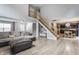 Open-concept living room with stairs leading to the upper level and an adjacent modern kitchen at 11919 Gatwick View Dr, Fishers, IN 46037