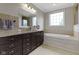 Luxurious bathroom featuring a soaking tub, granite countertops, and dark wood cabinetry at 11984 Talnuck Cir, Fishers, IN 46037