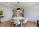 Bright dining room with modern light fixture and view to the kitchen through the hallway at 11984 Talnuck Cir, Fishers, IN 46037