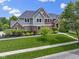 Beautiful two-story home featuring a manicured lawn, brick facade, and mature landscaping at 11984 Talnuck Cir, Fishers, IN 46037
