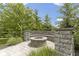 Close up of stone firepit with seating area surrounded by lush landscaping at 11984 Talnuck Cir, Fishers, IN 46037