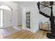 Bright foyer with a beautiful staircase, hardwood floors, an arched doorway, and wainscoting at 11984 Talnuck Cir, Fishers, IN 46037