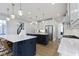 Open kitchen with double islands, modern lighting, white cabinets, and stainless steel appliances at 11984 Talnuck Cir, Fishers, IN 46037