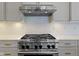 Gourmet kitchen featuring a stainless steel range and hood against a white subway tile backsplash at 11984 Talnuck Cir, Fishers, IN 46037