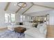 Spacious living room featuring a large sectional sofa, coffered ceiling, and open layout to the kitchen at 11984 Talnuck Cir, Fishers, IN 46037