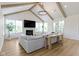 Bright living room with wood beams, fireplace, modern chandelier, and large windows offering natural light at 11984 Talnuck Cir, Fishers, IN 46037