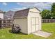 Backyard shed with a pathway, surrounded by grass and a wooden fence at 1222 Grand Canyon Ct, Franklin, IN 46131