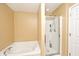 Bathroom with tub and shower featuring glass doors, white fixtures and neutral colors at 1222 Grand Canyon Ct, Franklin, IN 46131