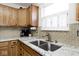 Close-up of kitchen sink with stainless steel faucet, granite countertops and wooden cabinets at 1222 Grand Canyon Ct, Franklin, IN 46131