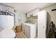 Functional laundry room with washer, dryer, white cabinets, and a hot water heater at 1222 Grand Canyon Ct, Franklin, IN 46131