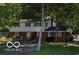 Charming two-story home featuring a brick facade, black shutters, well-manicured lawn, and mature trees at 1238 N 650 W, Anderson, IN 46011
