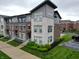 Modern townhome with brick and stone facade, manicured landscaping, and a welcoming entrance at 12908 Grand Blvd, Carmel, IN 46032