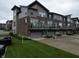 Rear view of modern townhomes, highlighting private garages and balcony spaces at 12908 Grand Blvd, Carmel, IN 46032