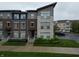 Stylish townhome exterior showcasing brick and stone accents, complemented by lush green landscaping at 12908 Grand Blvd, Carmel, IN 46032
