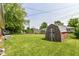 Large backyard featuring a vintage shed, a green lawn, and mature trees at 1308 N Main St, Lapel, IN 46051