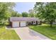 Charming ranch home with brick accents, mature trees, a two-car garage, and a wide driveway at 1308 N Main St, Lapel, IN 46051
