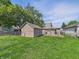Backyard featuring green grass, a detached garage, a wooden deck, and a chain-link fence at 145 S 7Th Ave, Beech Grove, IN 46107