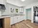 Kitchen features white cabinetry, modern appliances, and wood-look flooring at 145 S 7Th Ave, Beech Grove, IN 46107