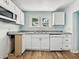 Bright kitchen features white cabinetry, modern appliances, and wood-look flooring at 145 S 7Th Ave, Beech Grove, IN 46107