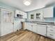 Bright kitchen features white cabinetry, modern appliances, and wood-look flooring at 145 S 7Th Ave, Beech Grove, IN 46107