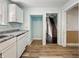 Kitchen features white cabinetry and wood-look flooring at 145 S 7Th Ave, Beech Grove, IN 46107