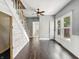 View of living room showing hardwood floors, ceiling fan, trim details, and a partial view of the staircase at 145 S 7Th Ave, Beech Grove, IN 46107