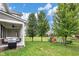 Large, well-maintained backyard featuring covered patio with grill and outdoor play set at 14931 W Black Wolf Run Dr, Carmel, IN 46033