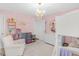 Inviting pink bedroom with a playful dollhouse and a comfy white chair, creating a cozy retreat for relaxation and imaginative play at 14931 W Black Wolf Run Dr, Carmel, IN 46033