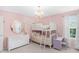 Charming pink bedroom featuring a white bunk bed, a dresser with mirror and a desk, creating a functional and delightful space at 14931 W Black Wolf Run Dr, Carmel, IN 46033